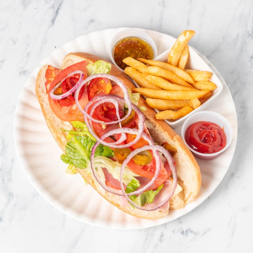 St. Lucie West Pizzeria's sub sandwich with ham, cheese, lettuce, tomato, onion, and jalapeños, with fries and sauces.