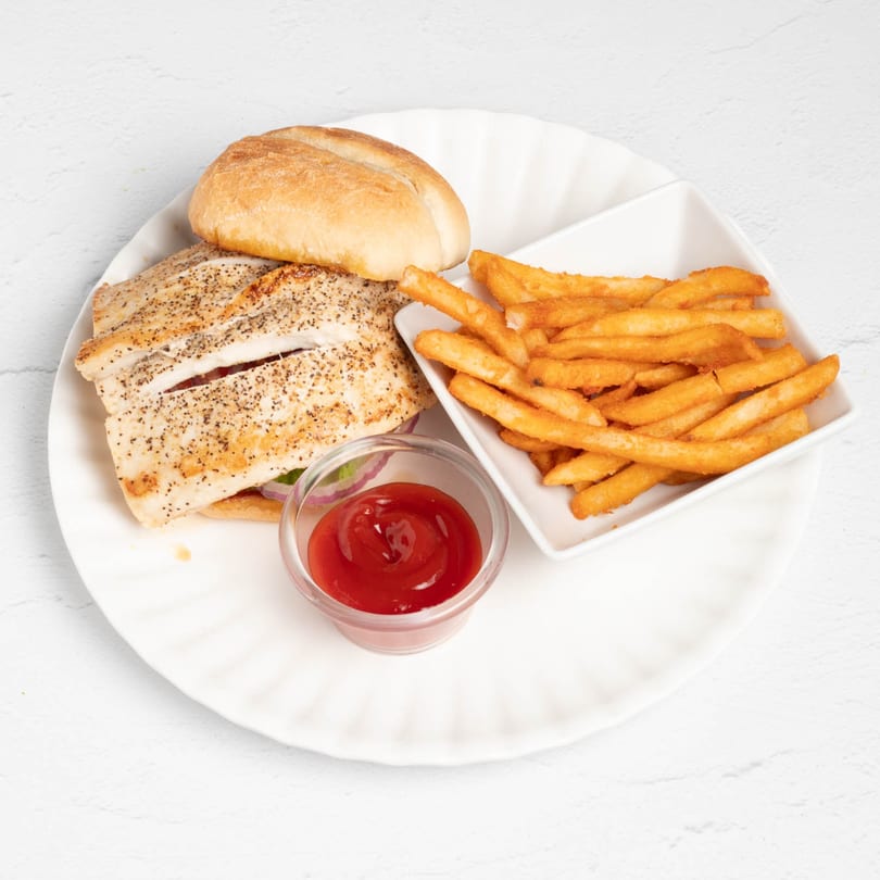 Grilled fish sandwich with fries and ketchup on a white plate from St. Lucie West Pizzeria.