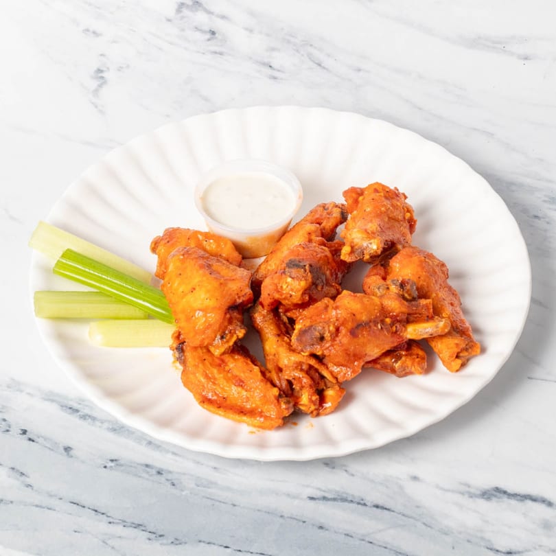 St. Lucie West Pizzeria's buffalo wings with celery sticks and a side of ranch dressing.